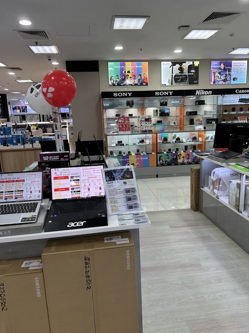 Interior view of an electronics store showcasing laptops, cameras, and other gadgets.
