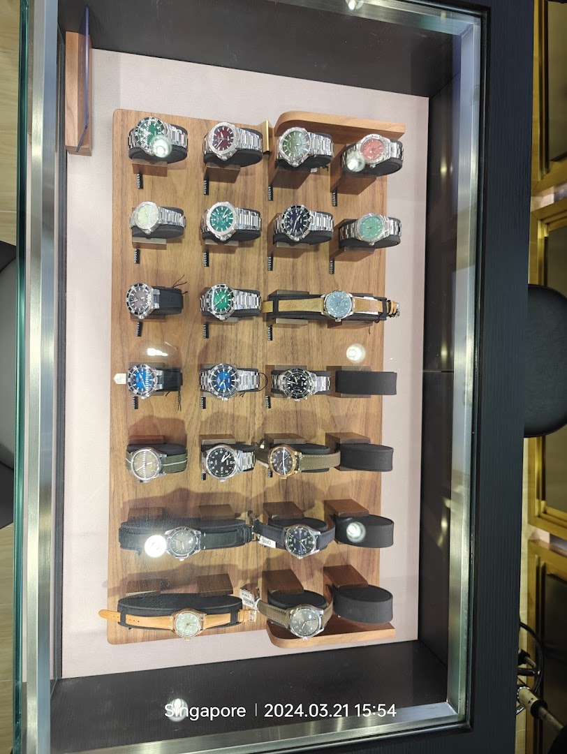 A display case showcasing a variety of luxury watches on wooden stands.