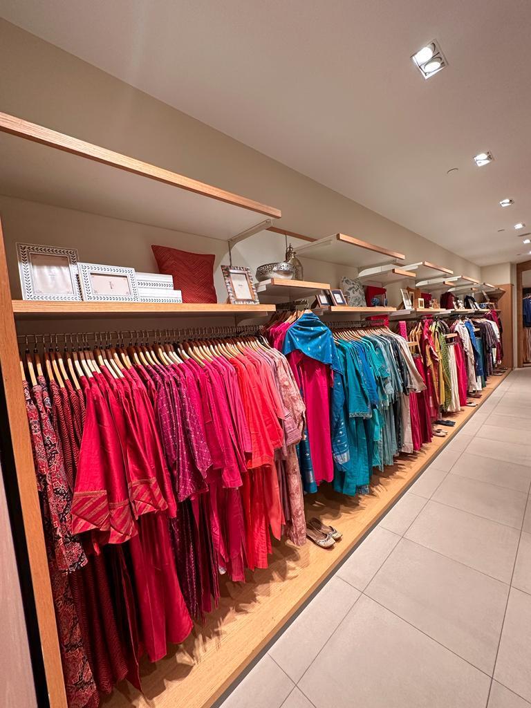 Interior view of a clothing store with racks of colorful ethnic wear.
