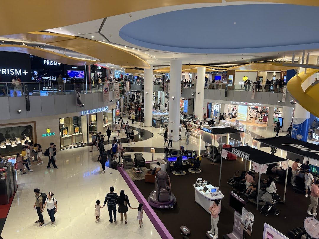 A busy shopping mall interior with various shops and shoppers on multiple levels.