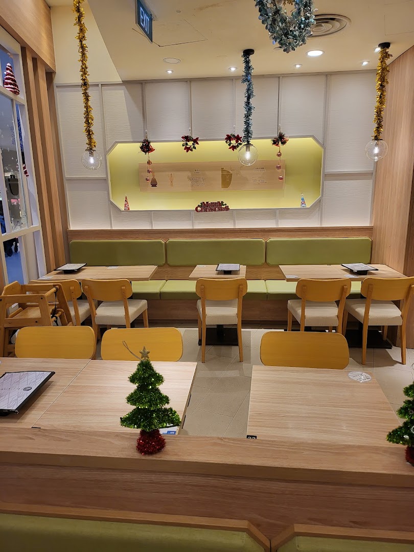 Interior of a cafe with wooden tables, chairs, and festive Christmas decorations.