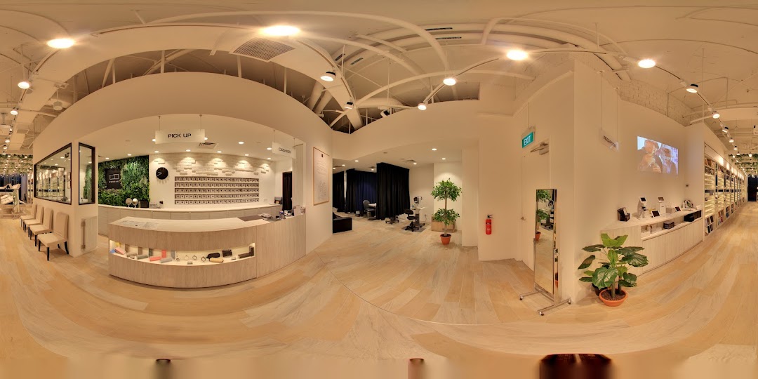 Interior view of a modern optical shop with a reception desk, seating, and display shelves.