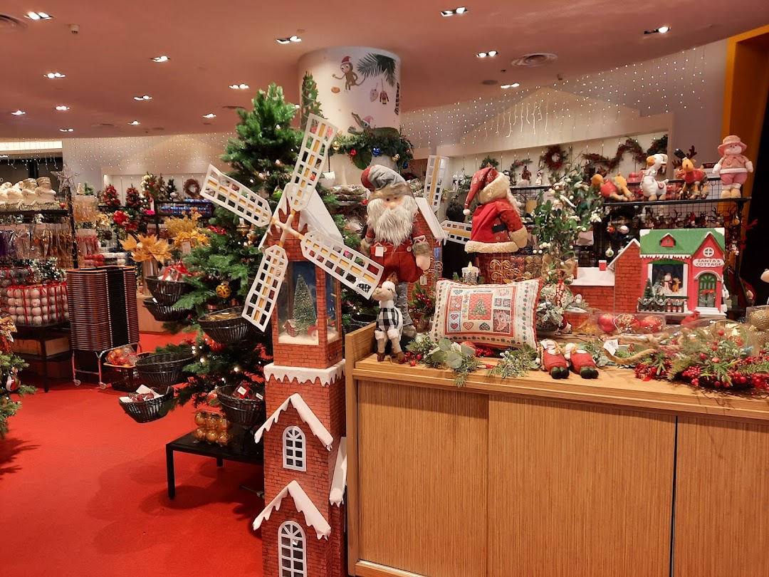A festive Christmas display featuring Santa figures, a windmill, Christmas trees, and holiday decorations.