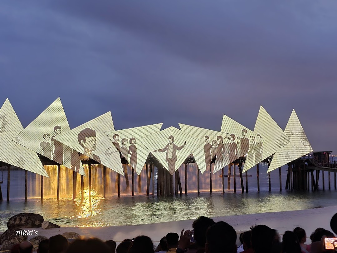A water and light show with projected images of people on angled screens.